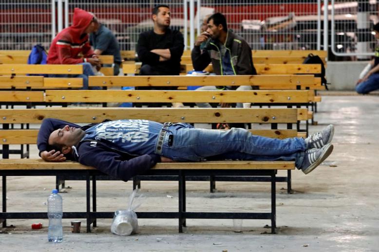 شخص ينام في الشارع على مقعد