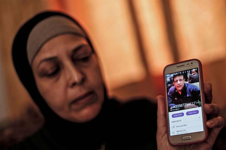 The sister of Zaki Mubarak shows his picture during an interview in their family home in Deir al-Balah