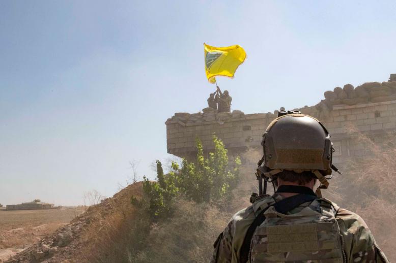 US Soldier oversees members of the Syrian Democratic Forces as they demolish a Kurdish fighters' fortification near Syria's border with Turkey
