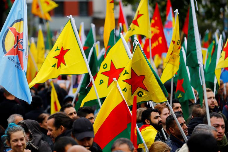 Pro-Kurdish demonstrators wave flags of the Kurdish YPG militia in Cologne, Germany