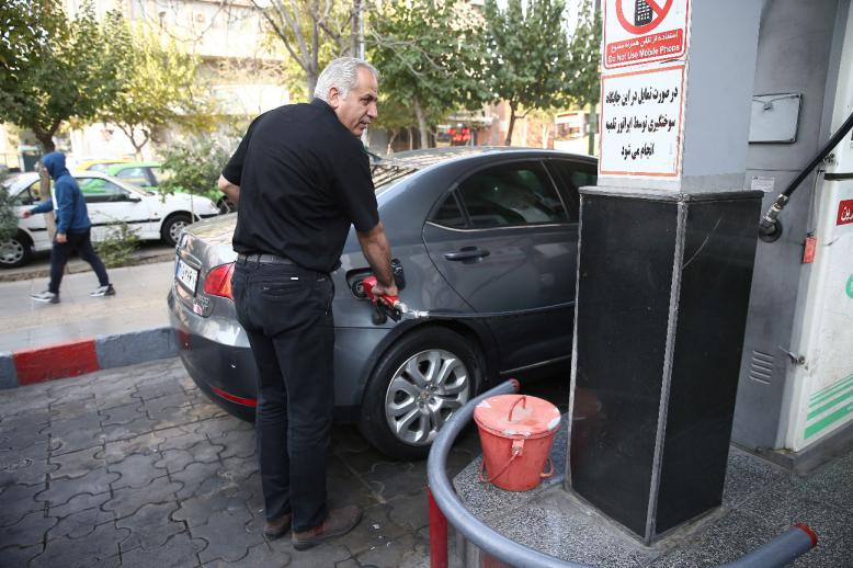 A man fills up his car's tank at a petrol station, after fuel price increased, in Tehran