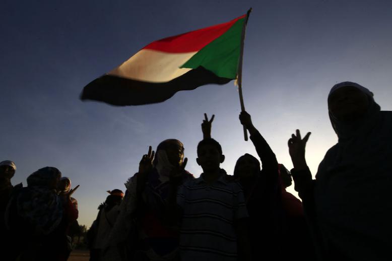 Demonstrators wave the Sudanese flag in Khartoum