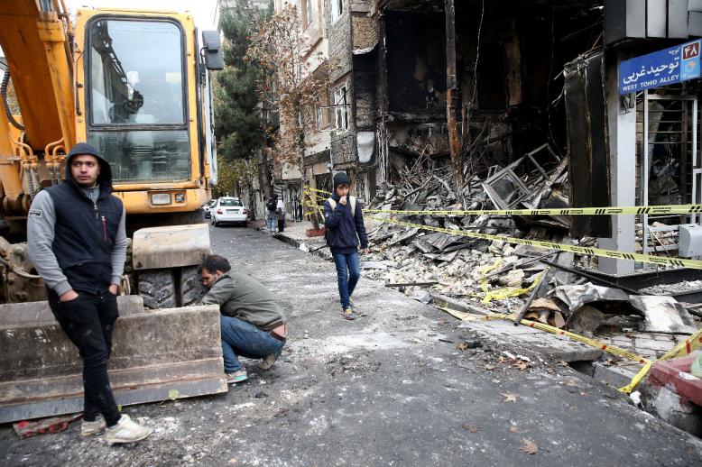People walk near a burnt bank, after protests against increased fuel prices, in Tehran, Iran November 20, 2019