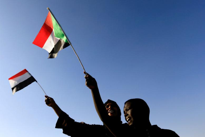 Sudanese civilians wave their national flag