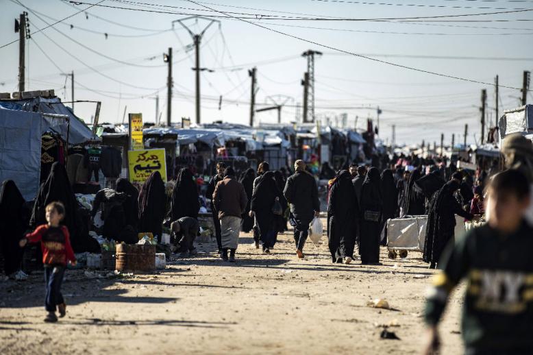 People gather at a market inside the Kurdish-run al-Hol camp in northeastern Syria