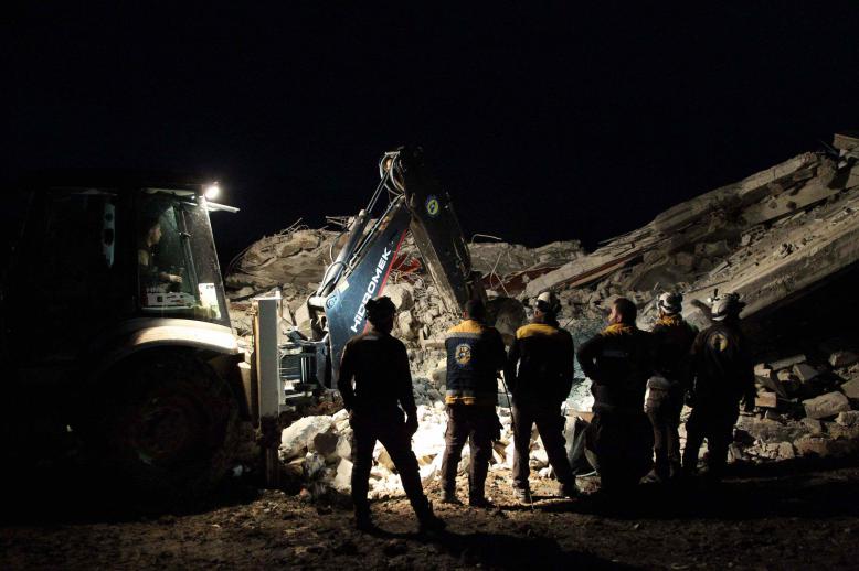 Members of the Syrian Civil Defence, also known as the White Helmets, search for survivors following an air-strike on the flashpoint town of Maaret al-Numan