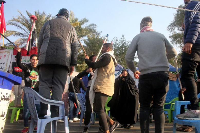 Iraqi anti-government protesters celebrate outside their protest tents in Baghdad's Tahrir Square following news of the killing of Qassem Soleimani