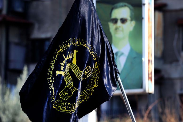 Mourners carry the flag of Islamic Jihad during the funeral of two members at Yarmuk, a Palestinian refugee camp south of Damascus