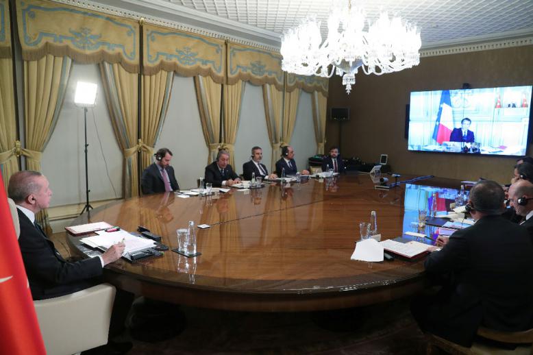 Turkish President Recep Tayyip Erdogan (L) attends a teleconference with European leaders
