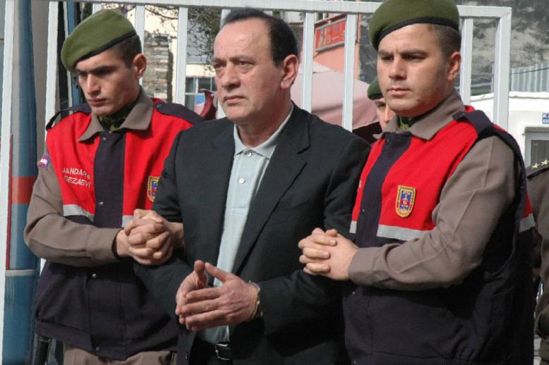 April 11, 2008 file photo, paramilitary police offices escort Alaattin Cakici before a trial in Istanbul.