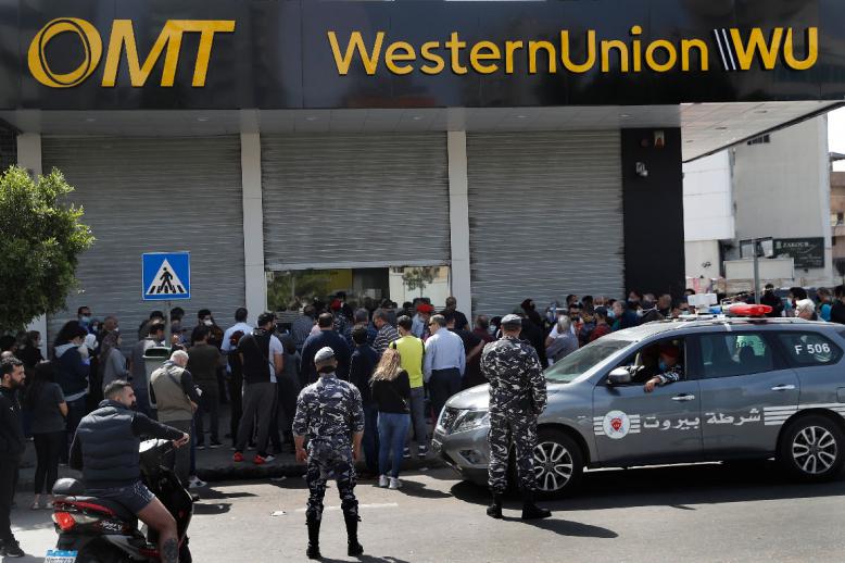 Lebanese citizens queue outside a Western Union shop to receive their money transfer in U.S. dollar currency