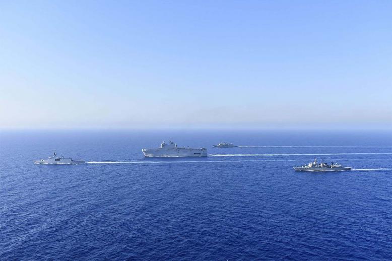 French Tonnerre helicopter carrier, center, and French Lafayette frigate, left, are escorted by Greek and French military vessels 