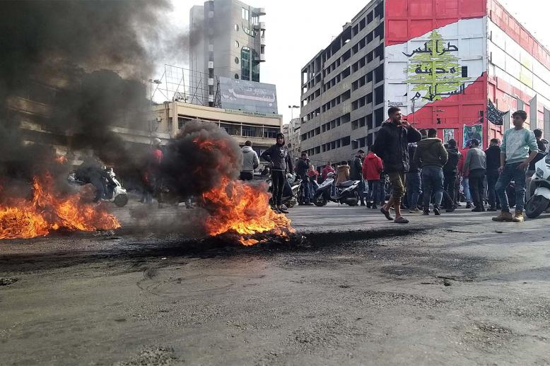 Demonstrators gather near burning tires during a protest against the lockdown and worsening economic conditions