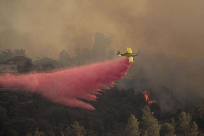 A plane sprays wildfires burning for for the second day near Shoresh, on the outskirts of Jerusalem