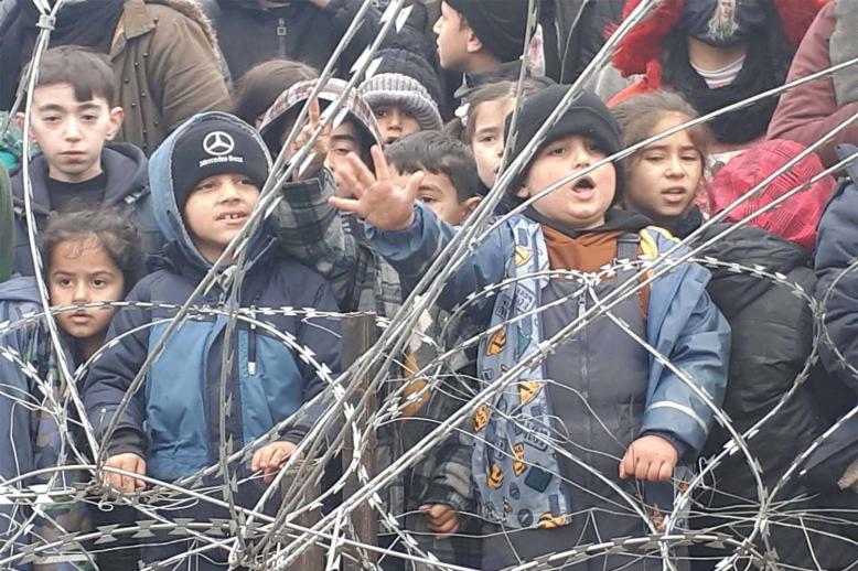 Migrants children gather near the fence on the Poland/Belarus border near Kuznica, Poland