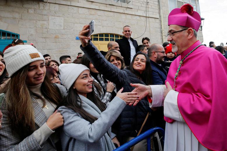 Pizzaballa greets people as he arrives to attend Christmas celebrations in Bethlehem