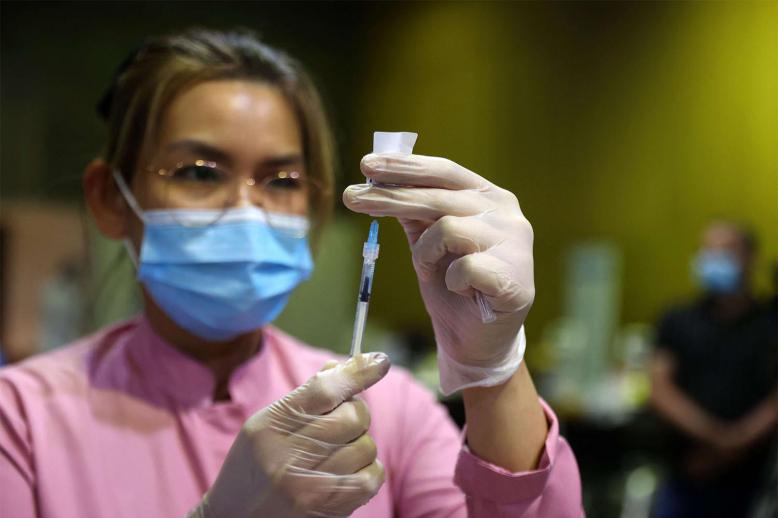 A health worker prepares a dose of the COVID-19 vaccine in Doha