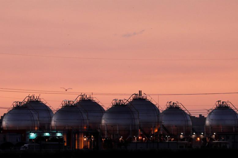 A plant's gas tanks are seen during sunset along a highway of Alexandria