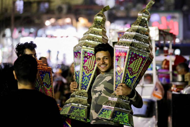 مصري يرفع فوانيس رمضان في أحد أسواق القاهرة