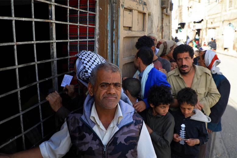 Yemenis wait in line to receive a free fast-breaking "Iftar" meal in Sanaa