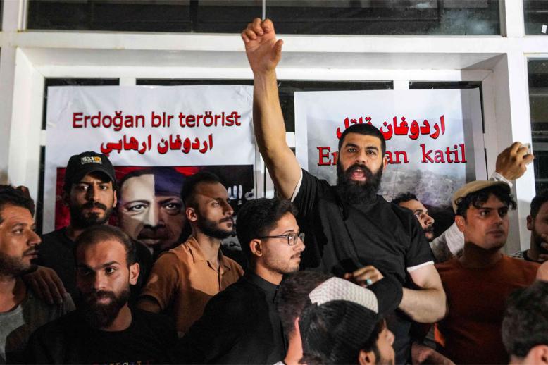Iraqi protesters shout sloganns in front of the Turkish visa application centre in the central city of Najaf