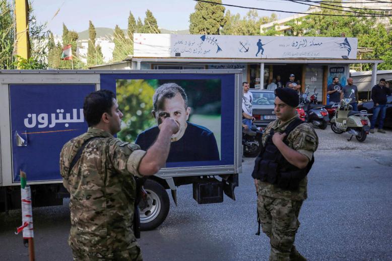 جنود لبنانيون أمام لوحة اعلان أثناء الحملة الانتخابية للتيار الحر