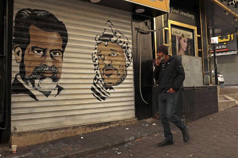 تخطيطان للرئيس العراقي الراحل صدام حسين والرئيس الفلسطيني الراحل ياسر عرفات على واجهة دكان في رام الله