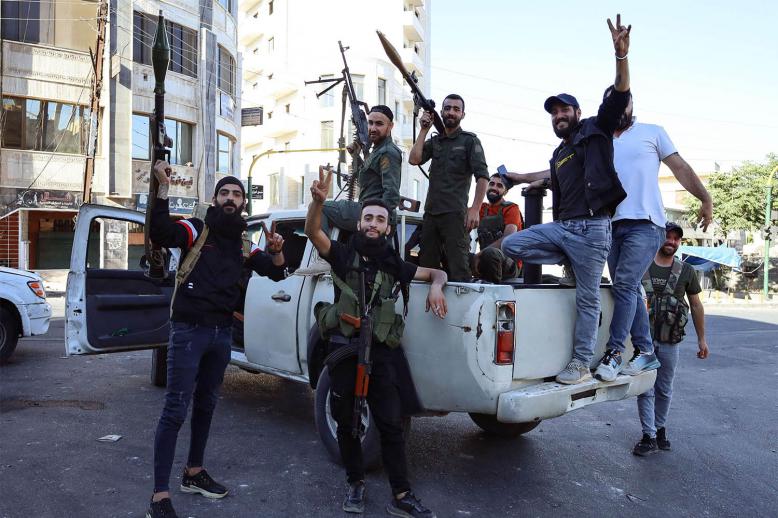 Syrian Druze fighters pose for a photograph after Syrian government forces pulled out of the Sweida governorate
