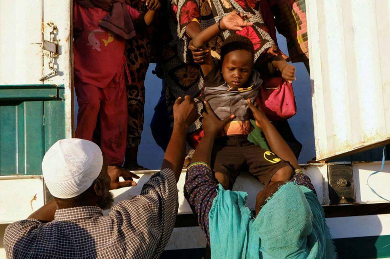 A displaced boy from al-Fashir gets down from a truck, at a displacement camp in Al-Dabba, Sudan, November 19, 2025. 