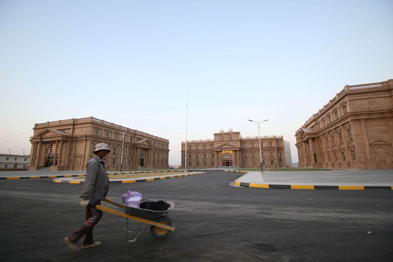 عامل يمر بالقرب من أبنية جامعية في البصرة