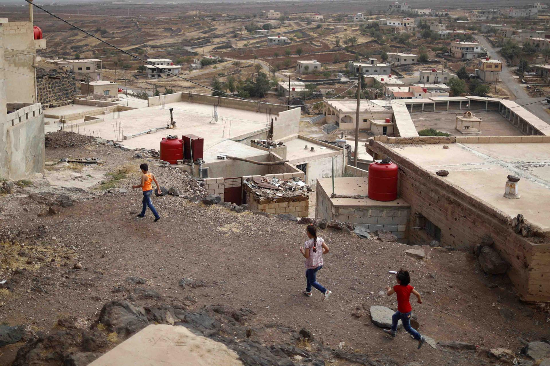 Druze children run at the village of Shreihi in the southern province of Sweida, Syria