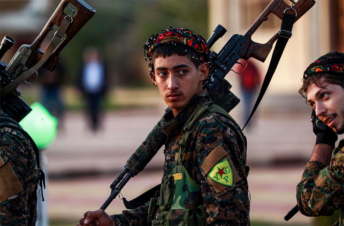 Syrian Democratic Forces fighters hold a sniper rifle 