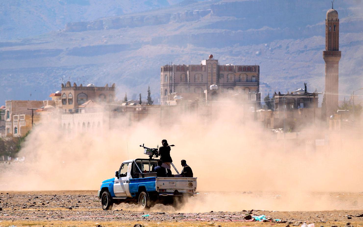 Yemeni men stand at the back of an armed pick up as people in the capital Sanaa to show their support to the Shiite Huthi movement against the Saudi-led intervention, on December 19, 2018.
