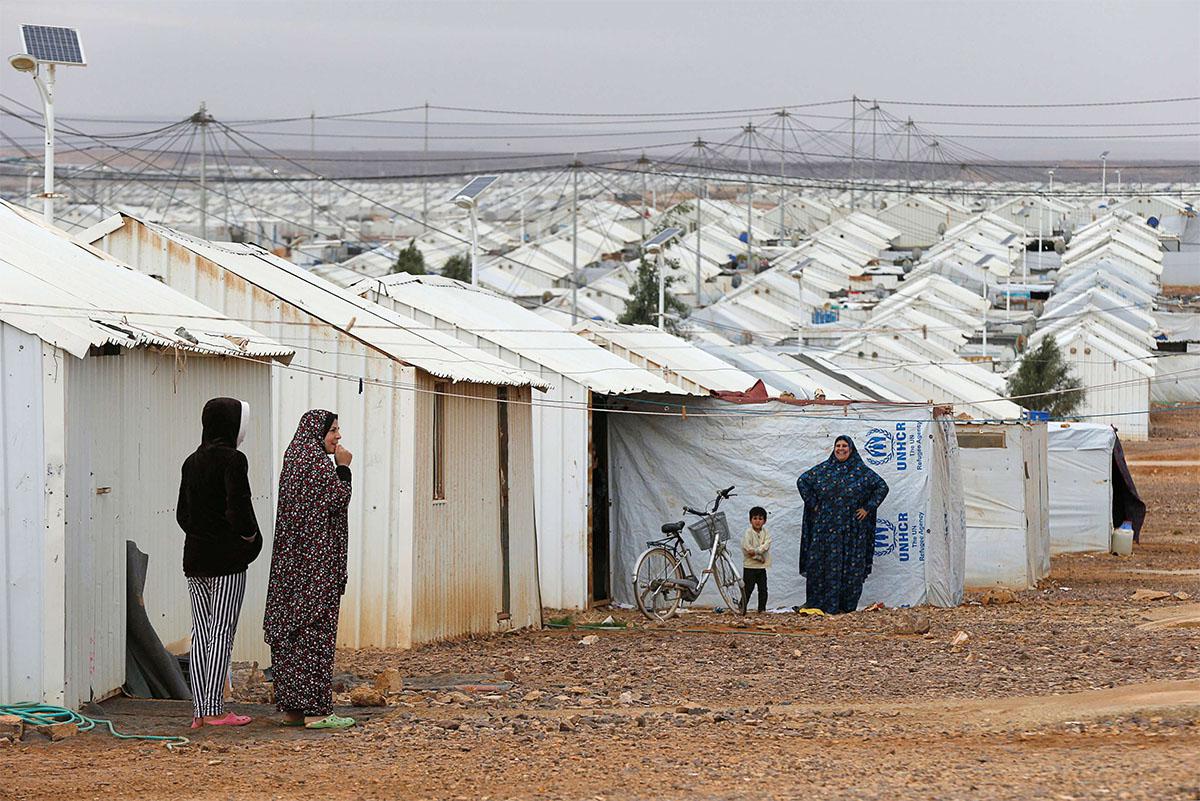 Syrian refugee women stand in front of their homes at Azraq refugee camp, near Al Azraq city, Jordan