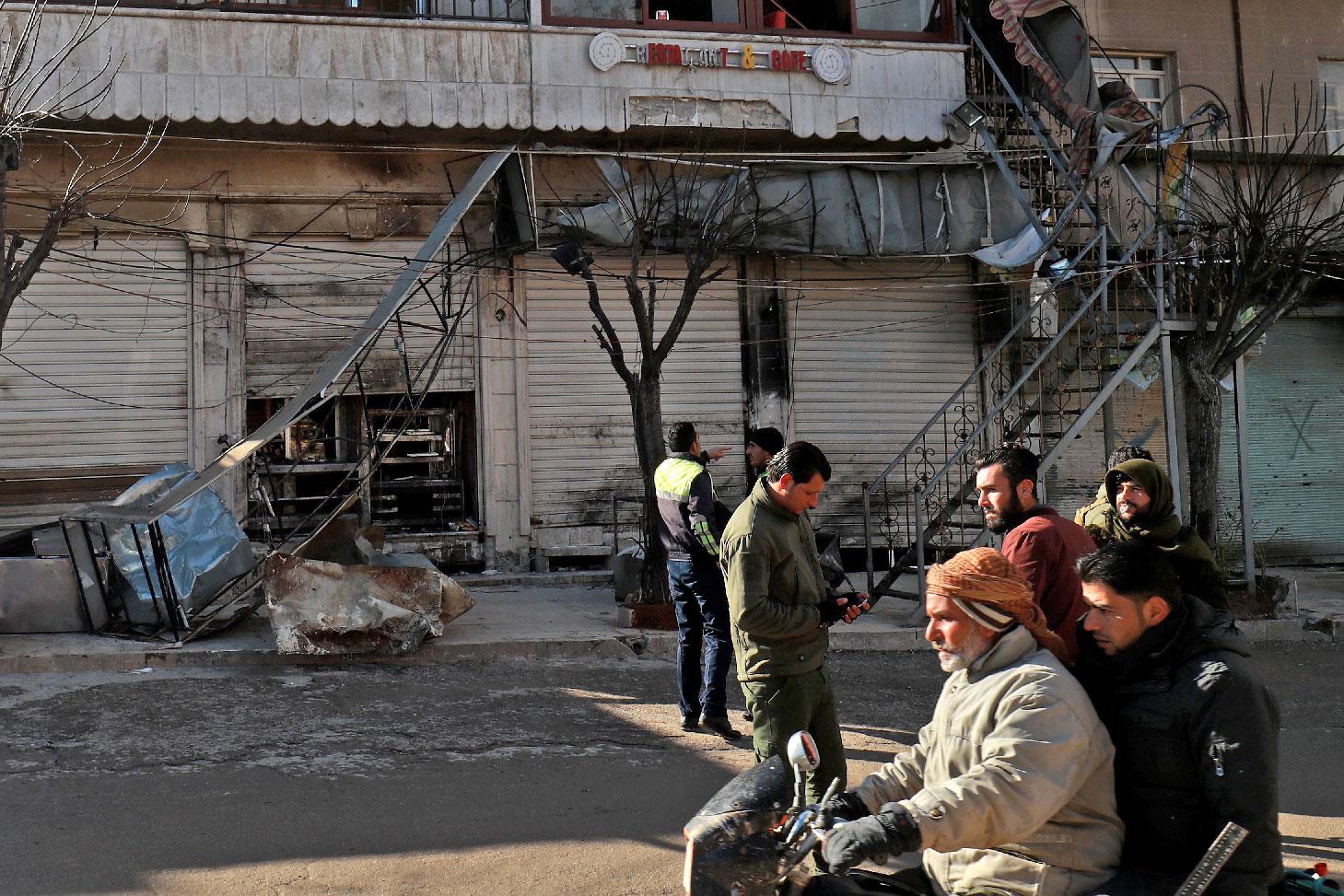 Syrians check the site a suicide attack targeting US-led coalition forces in the flashpoint northern Syrian city of Manbij which killed four US serviceman the previous day on January 17, 2019.