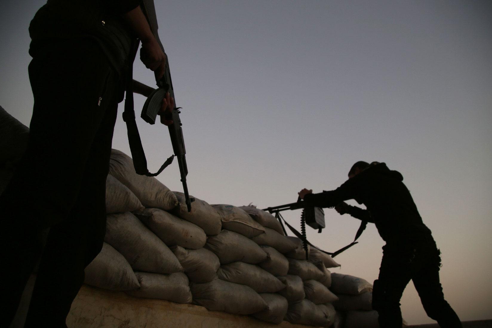 Turkish-backed Syrian fighters take up an armed position with sandbags along the frontline with SDF forces near the village of Kiridiyah, about 30 kilometres west of the northern town of Manbij, on January 15, 2019.