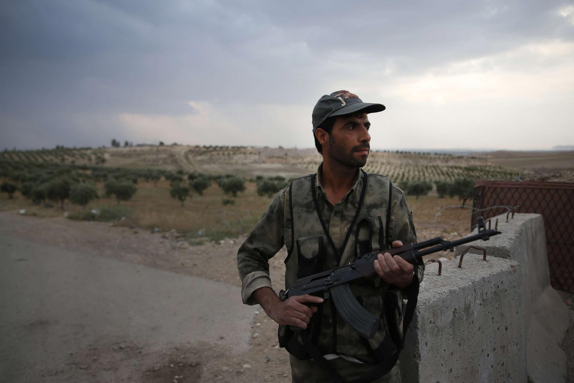 A Syrian security officer mans a checkpoint on the outskirts of Jarablus, northern Syria, Wednesday, May 30, 2018.