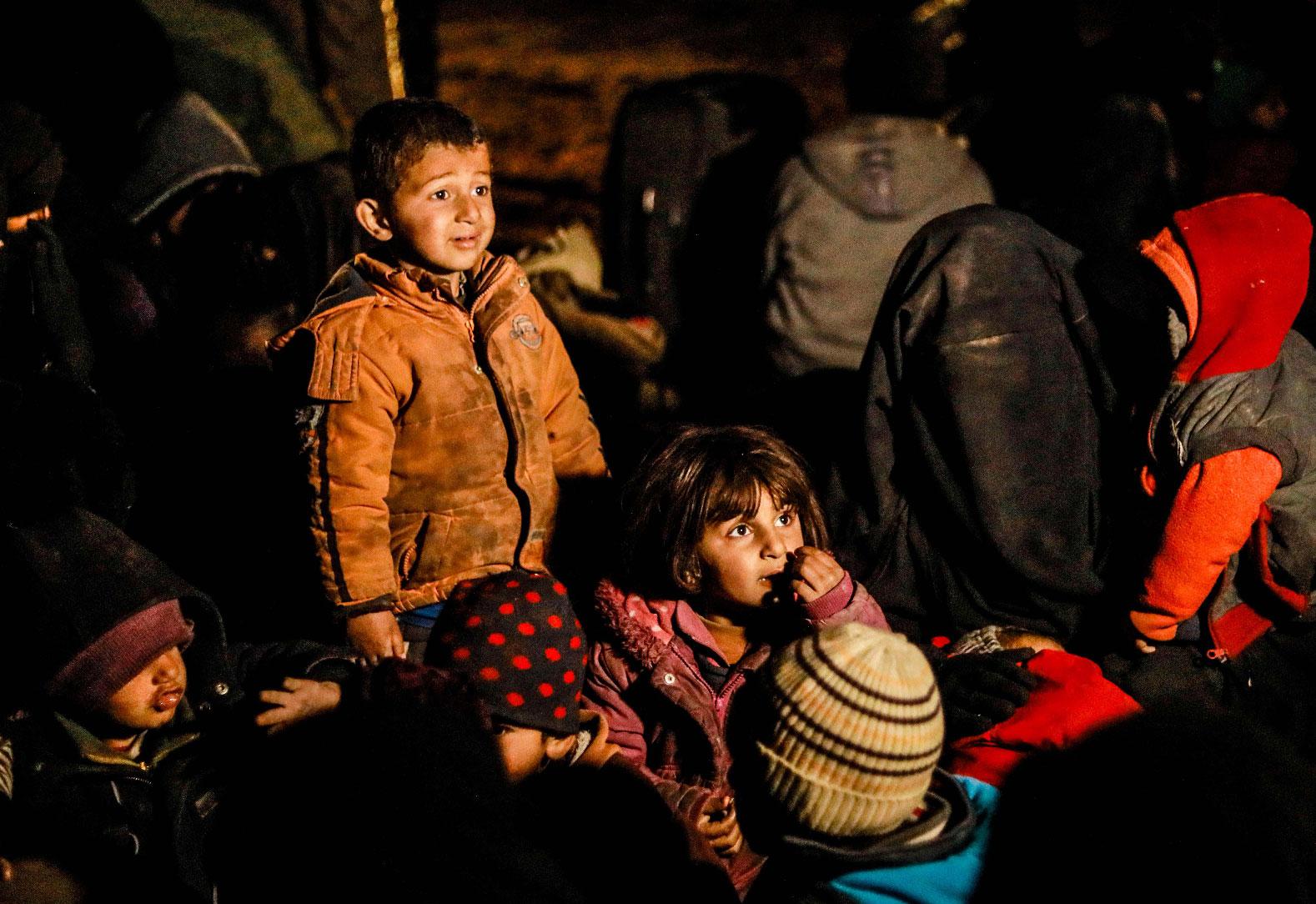 Women and children evacuated from the Islamic State (IS) group's embattled holdout of Baghouz wait in a zone held by the US-backed Syrian Democratic Forces (SDF) during an operation to expel IS jihadists from the area, in the eastern Syrian province of Deir Ezzor, on February 25, 2019.