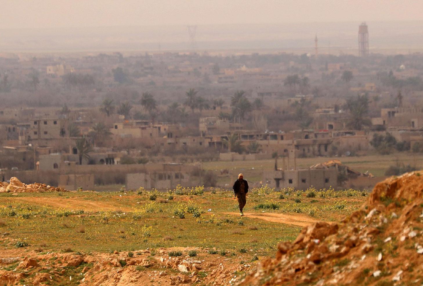A fighter with the US-backed Syrian Democratic Forces (SDF) walks at a position in the Baghouz area in the eastern Syrian province of Deir Ezzor on February 14, 2019 during an operation to expel hundreds of Islamic State group (IS) jihadists from the region.