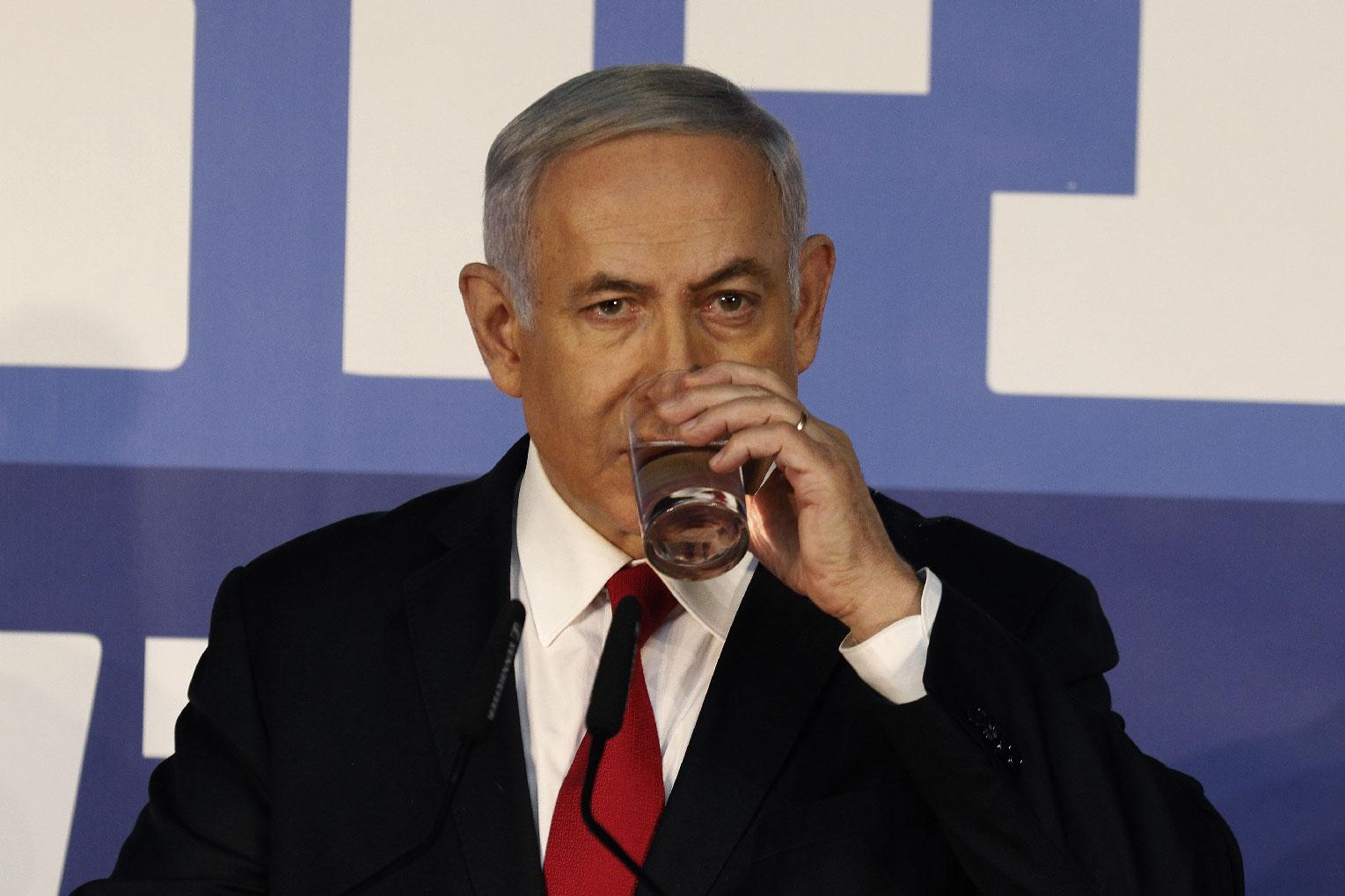 Israeli Prime Minister Benjamin Netanyahu drinks water as he delivers a statement to the press on February 28, 2019, at his residency in occupied Jerusalem.