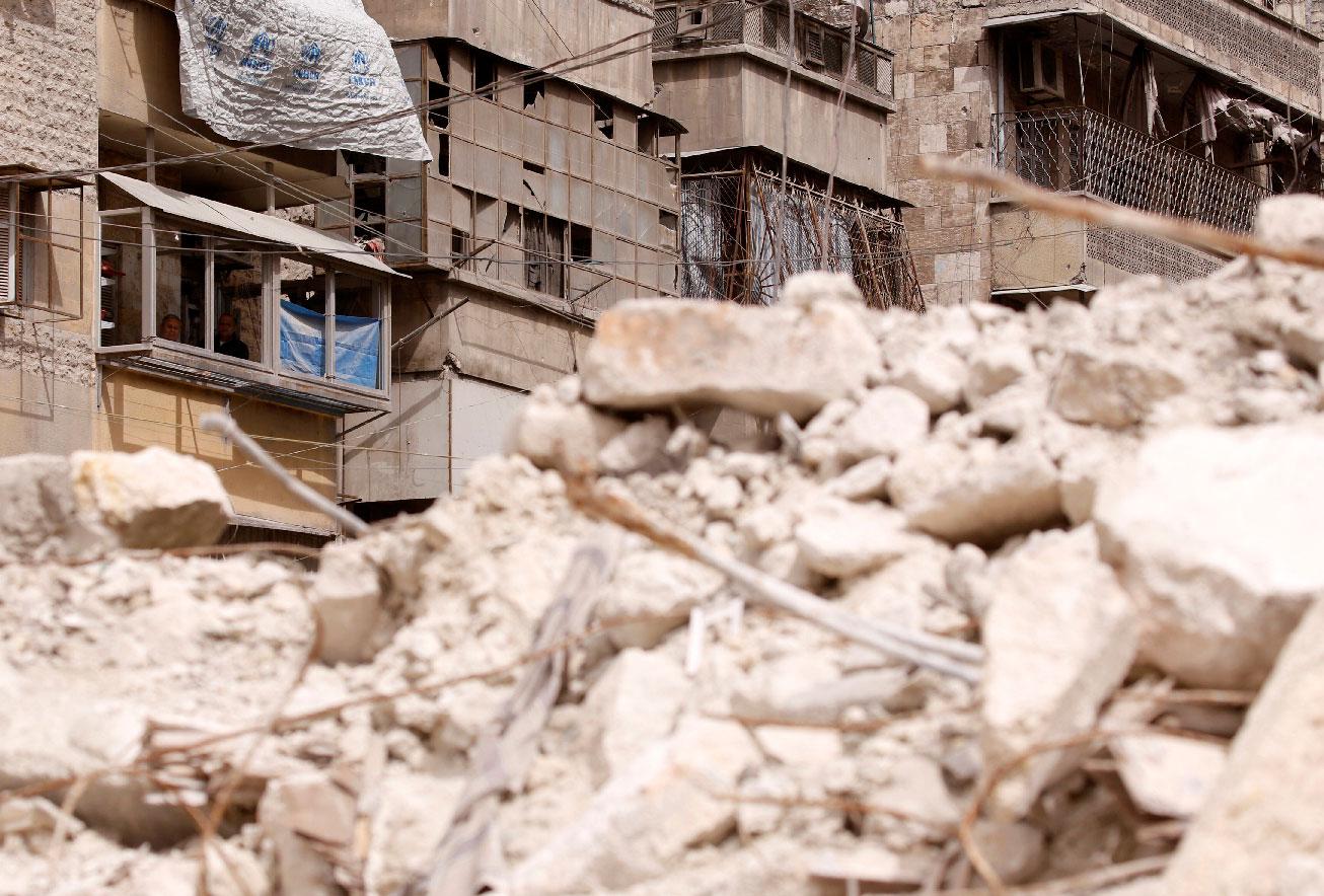 Malak Kasas' grandfather and uncle look out from their balcony overlooking rubble where she is still buried