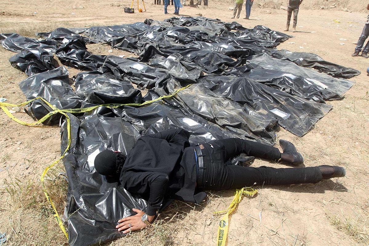 Iraqi man cries over body-bags containing the remains of people believed to have been slain by jihadists in TIkrit