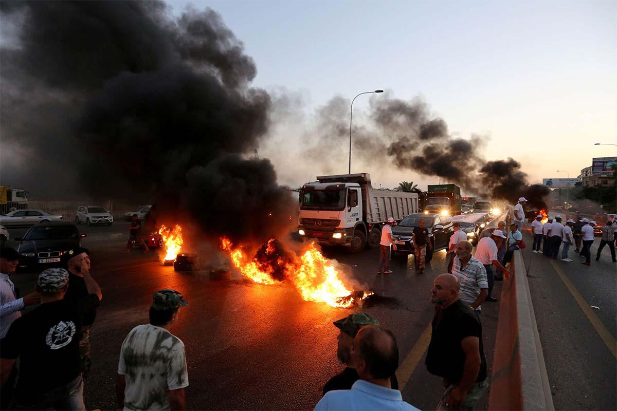 Army veterans burn tires during a protest over a state budget that includes a provision taxing their pensions