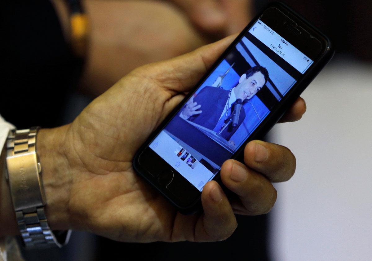 Ziad Zakka, brother of Nizar Zakka who is imprisoned in Iran, shows a photo of his brother on his cellular telephone in Beirut