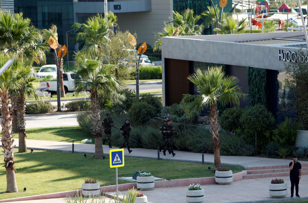Kurdish security members are seen near a restaurant where Turkish diplomats and Turkish consulate employee were killed in Erbil