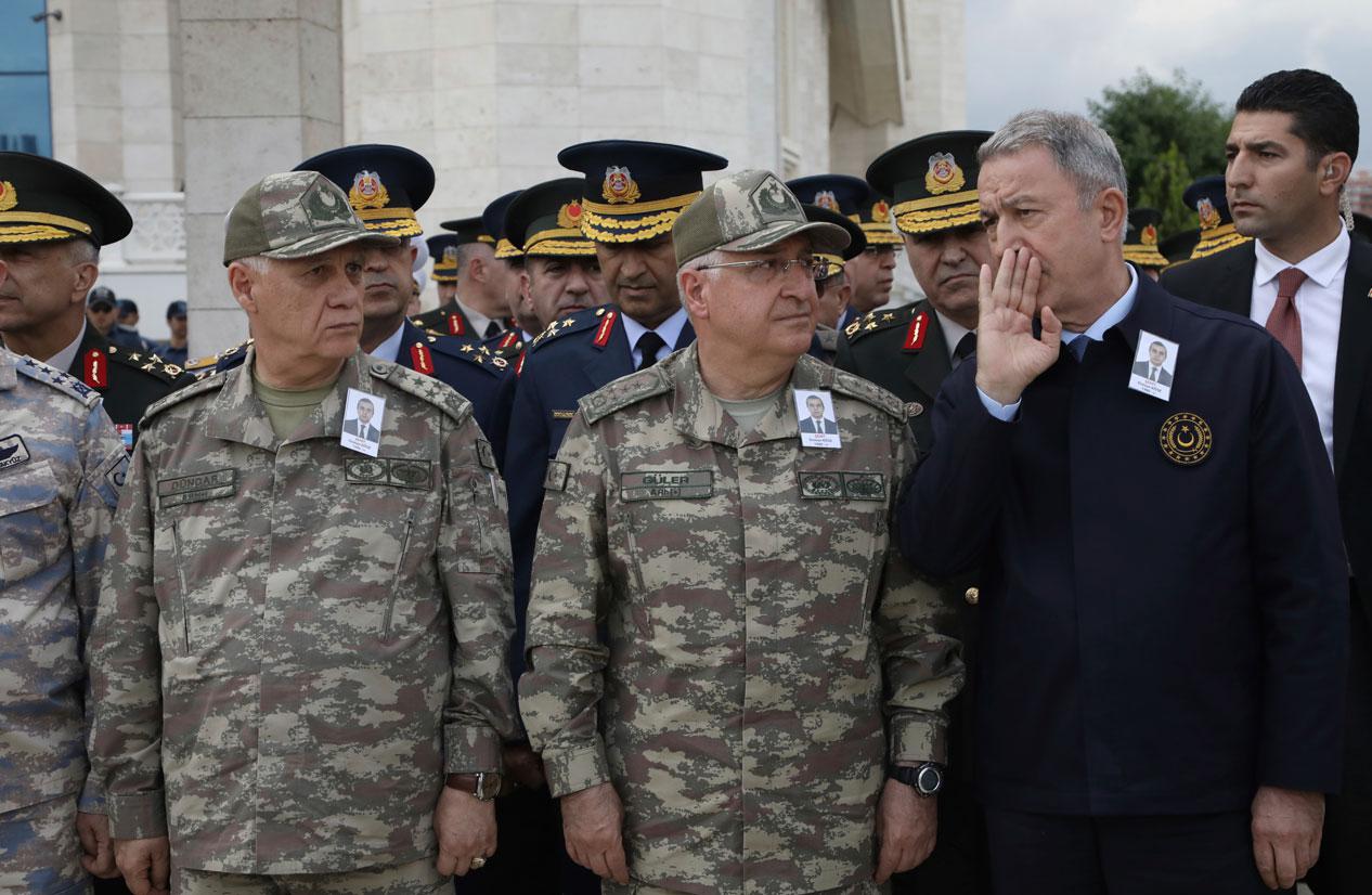 Turkey's Defense Minister Hulusi Akar, right, speaks with army's top commanders during the funeral of Turkish diplomat Osman Kose
