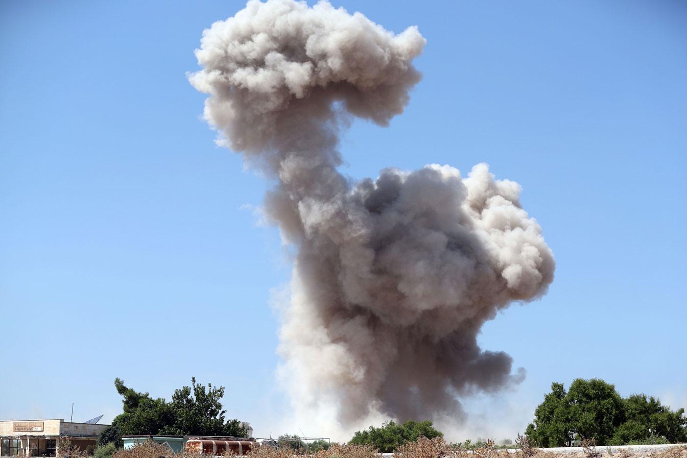 Smoke billows following a reported regime air strike in Idlib province
