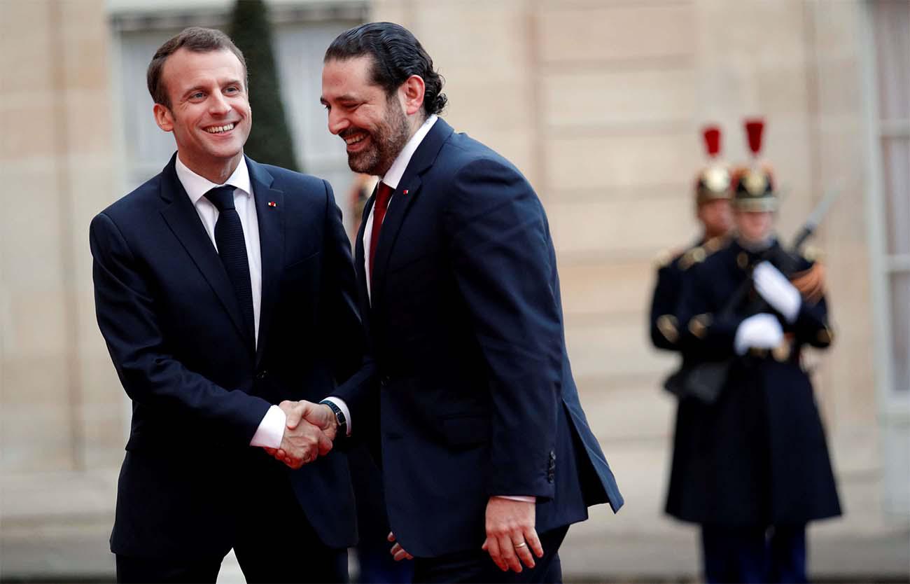 French President Emmanuel Macron welcomes Lebanese PM Saad al-Hariri as he arrives at the Elysee Palace last year