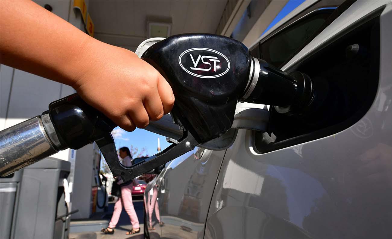 A child pumps gas for his father at a gas station in Los Angeles