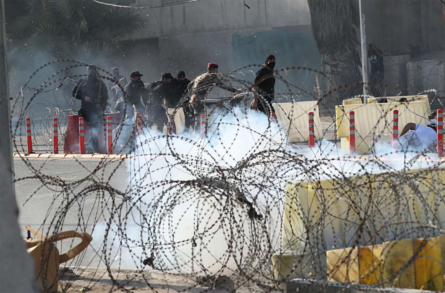 Iraqi security forces fire tear gas to disperse anti-government protesters during a demonstration in central Baghdad,